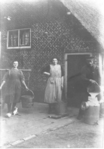 1000675 Afbeelding van twee vrouwen en een man met melkemmers te Jutphaas.